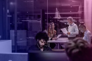 Meetingsituation in einem Glasbüro als Vorbereitung auf die Krisenkommunikation bei Cyberangriffen